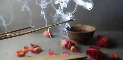 Bâton d'encens qui brule avec des pétales en arrière plan